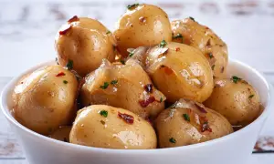 Miseczka pełna pysznych, błyszczących kiszonych ziemniaków z dodatkiem ziół i papryczki chili. Idealne jako dodatek do obiadu.