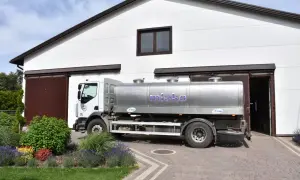 Ciężarówka z cysterną na mleko przed budynkiem. Sprawdź aktualne ceny mleka przerzutowego.