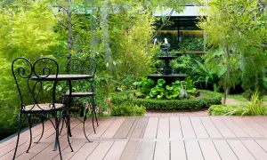 Uroczy zakątek z fontanną i stolikiem, idealny na relaks. Zastanawiasz się, jakie drzewko na balkon? Tutaj znajdziesz inspirację.
