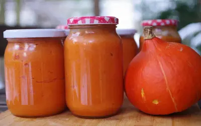Słoiki z przetartą dynią i świeża dynia. Zastanawiasz się, dlaczego dynia w słoikach fermentuje? To naturalny proces.